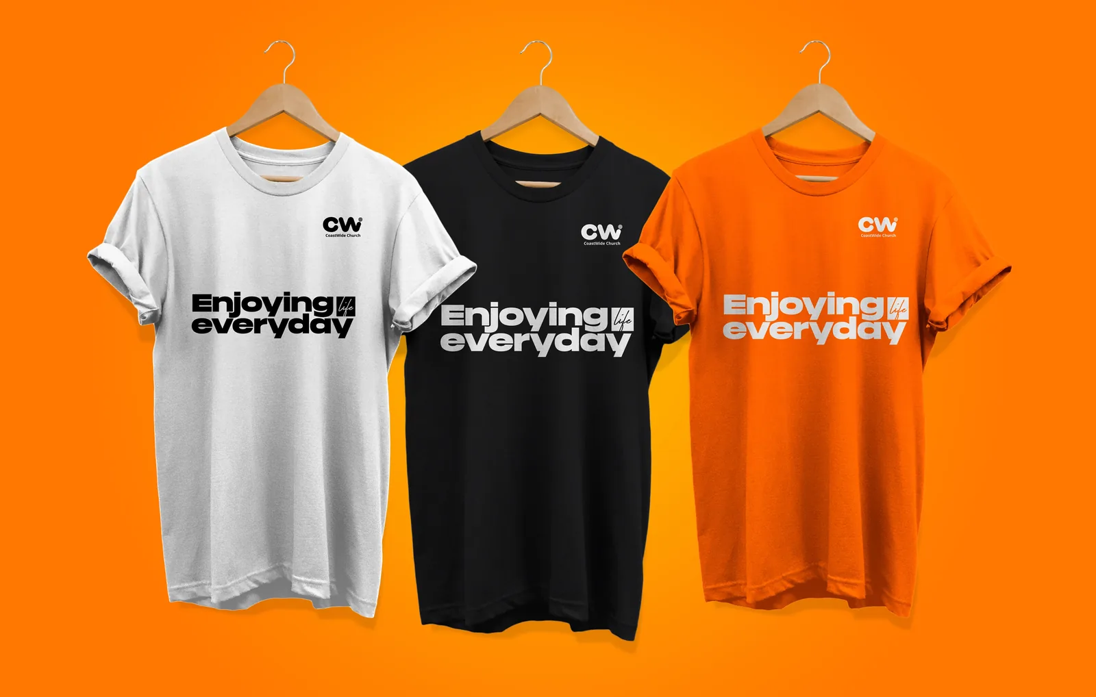 2022 identity on merch: white, black and orange T-shirts printed with the CW mark and 'Enjoying everyday'