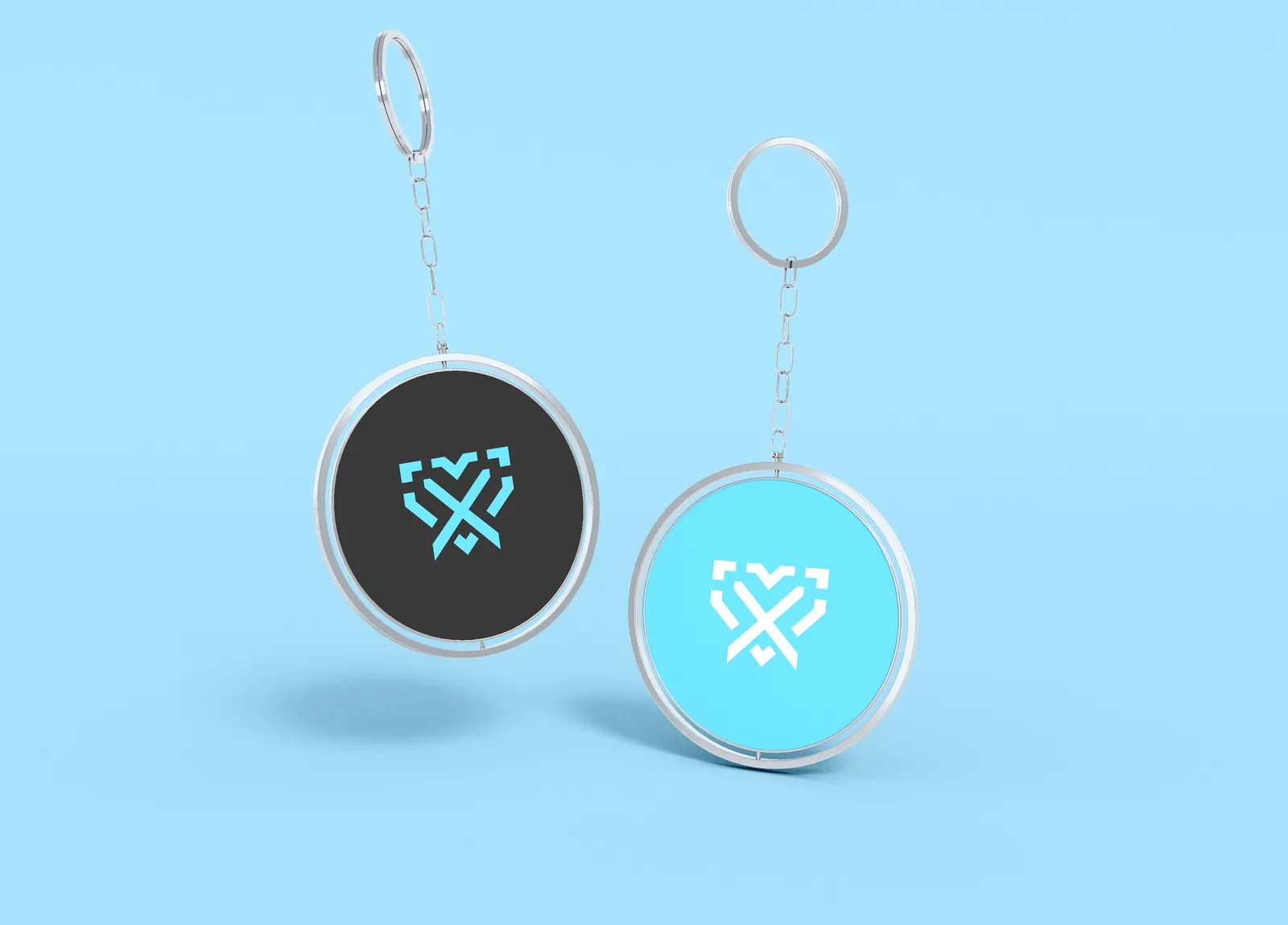 Two round Vixus keyrings, one black and one sky blue, each carrying the monogram
